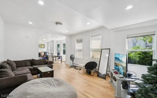 a living room with furniture a window and a flat screen tv