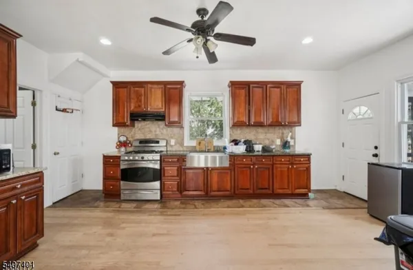 a kitchen with stainless steel appliances kitchen island granite countertop a stove a sink a refrigerator and a microwave