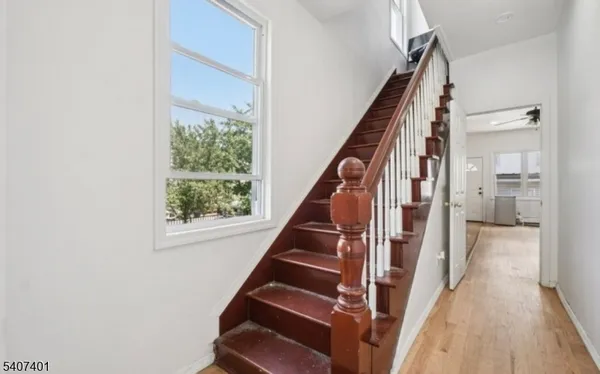 a view of an entryway with wooden floor and staircase