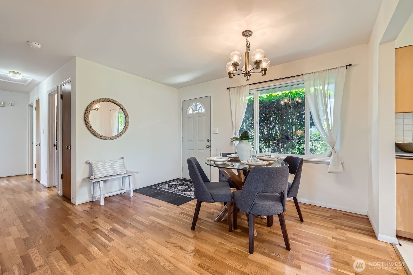 7924 South 112th Street Seattle, WA 98178 - Photo 4 of 40 a dining room with wooden floor a chandelier a wooden table and chairs