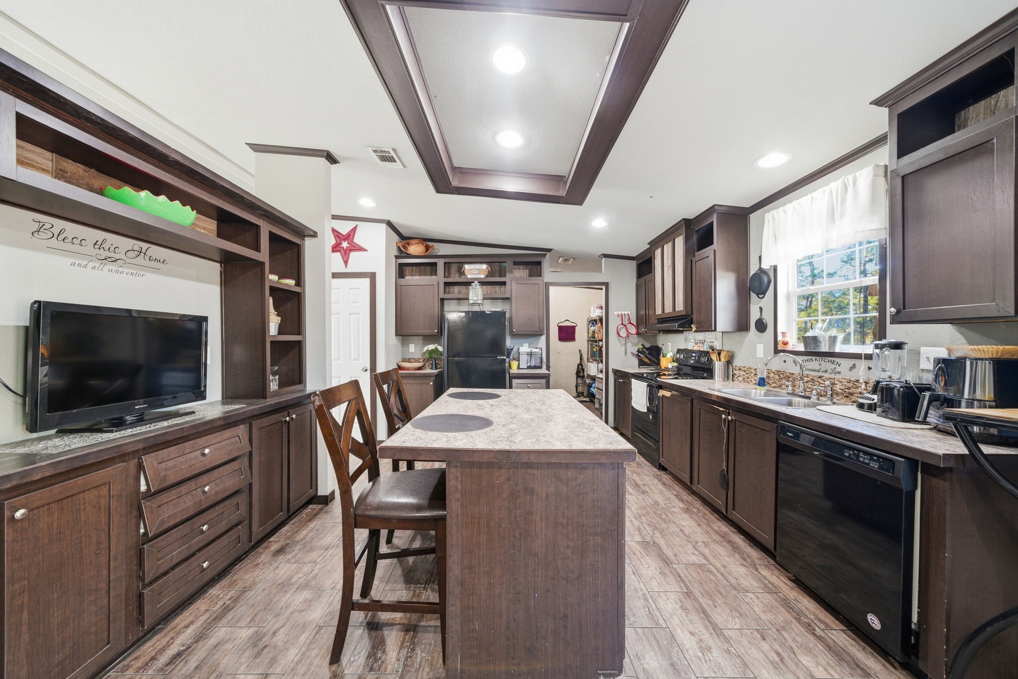 17028 Lively Road Waller, TX 77484 - Photo 4 of 20 a kitchen with stainless steel appliances granite countertop a stove top oven a sink dishwasher a dining table and chairs with wooden floor