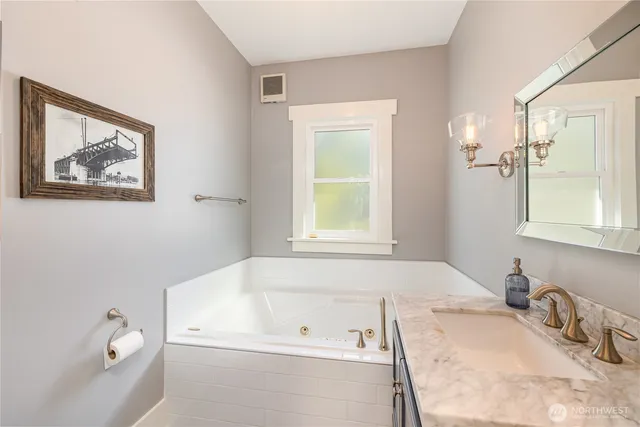 a bathroom with a tub sink and mirror