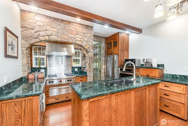 a kitchen with granite countertop a sink and a wooden floor