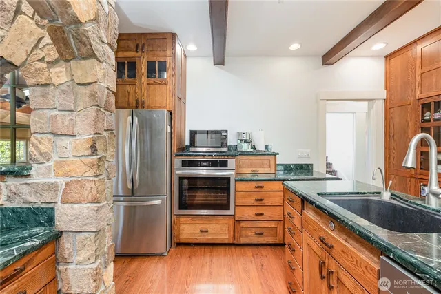a kitchen with granite countertop a refrigerator and a sink