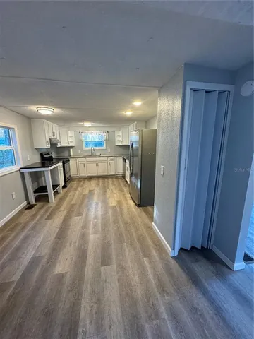 a view of a kitchen with a sink and wooden floor