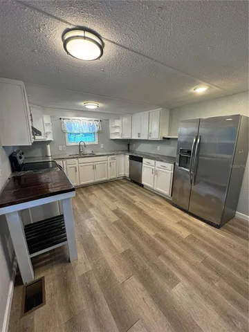 a kitchen with stainless steel appliances granite countertop a stove a sink and a microwave