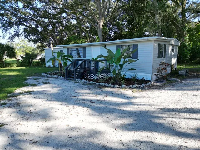 a view of a house with backyard and plants