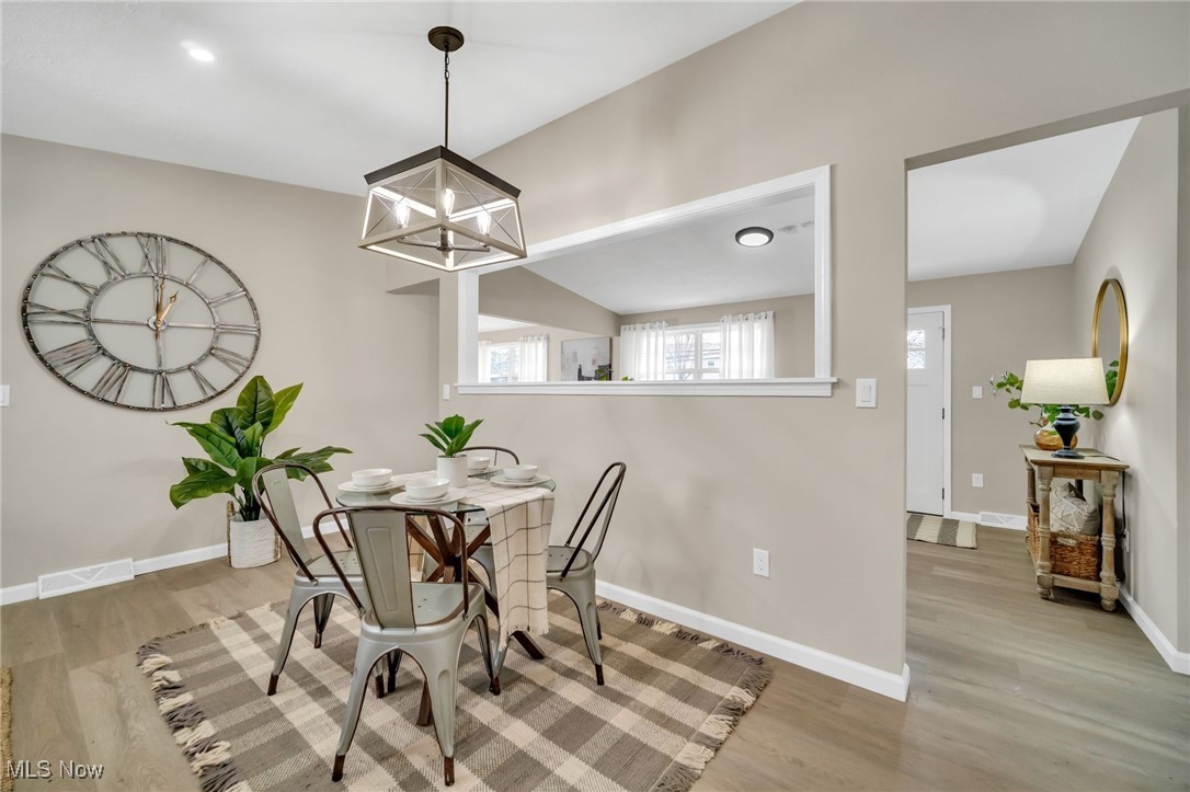 6320 Jaycox Road North Ridgeville, OH 44039 - Photo 13 of 34 Dining area featuring a chandelier, visible vents, baseboards, and wood finished floors