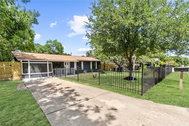a view of a house next to a yard with big trees