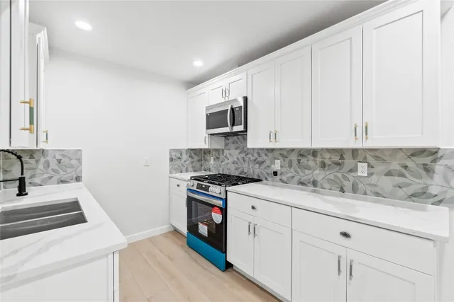 a kitchen with a sink stove and cabinets