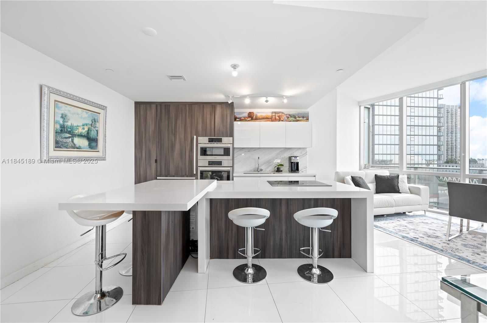 851 Northeast 1st Avenue, Unit 1410 Miami, FL 33132 - Photo 4 of 43 a kitchen with kitchen island granite countertop a sink and a stove