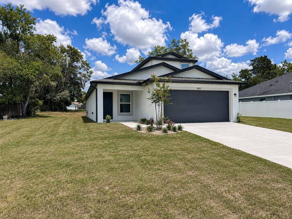 10405 Timbercrest Road Spring Hill, FL 34608 - Photo 3 of 14 a front view of a house with a yard and garage