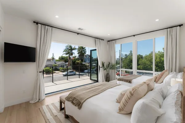 a spacious bedroom with a bed and a potted plant
