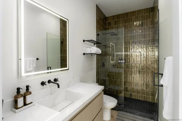 a bathroom with a sink a toilet and shower