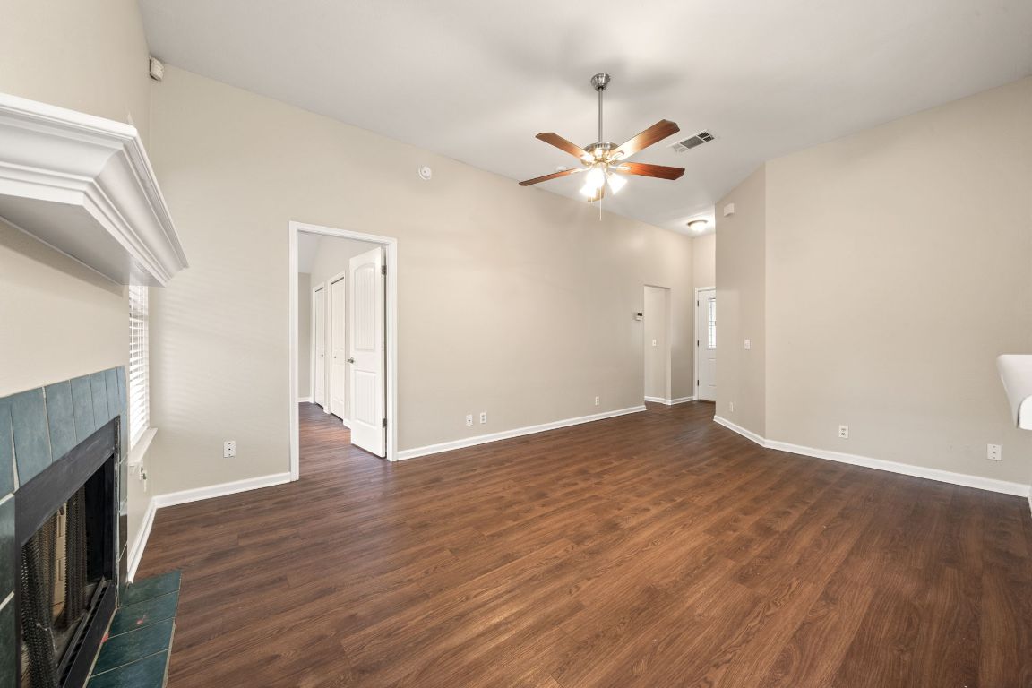 4904 Gnarled Oak Cove Austin, TX 78744 - Photo 14 of 38 an empty room with wooden floor fan and windows