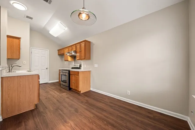 a kitchen with a wooden floor and a stove top oven