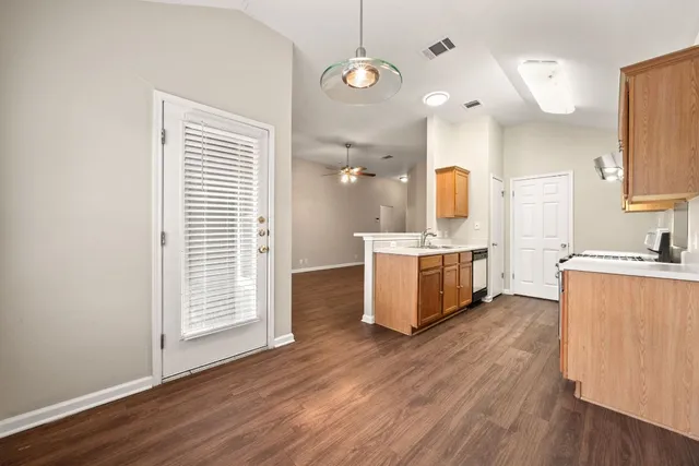 a view of a kitchen with wooden floor and windows