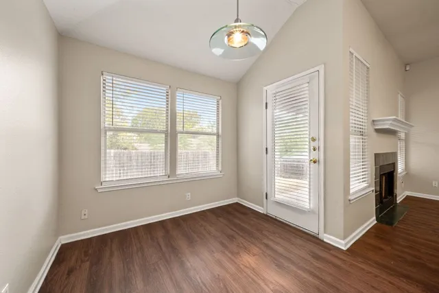 an empty room with wooden floor and a large window
