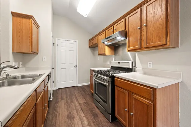 a kitchen with stainless steel appliances granite countertop a stove and a sink