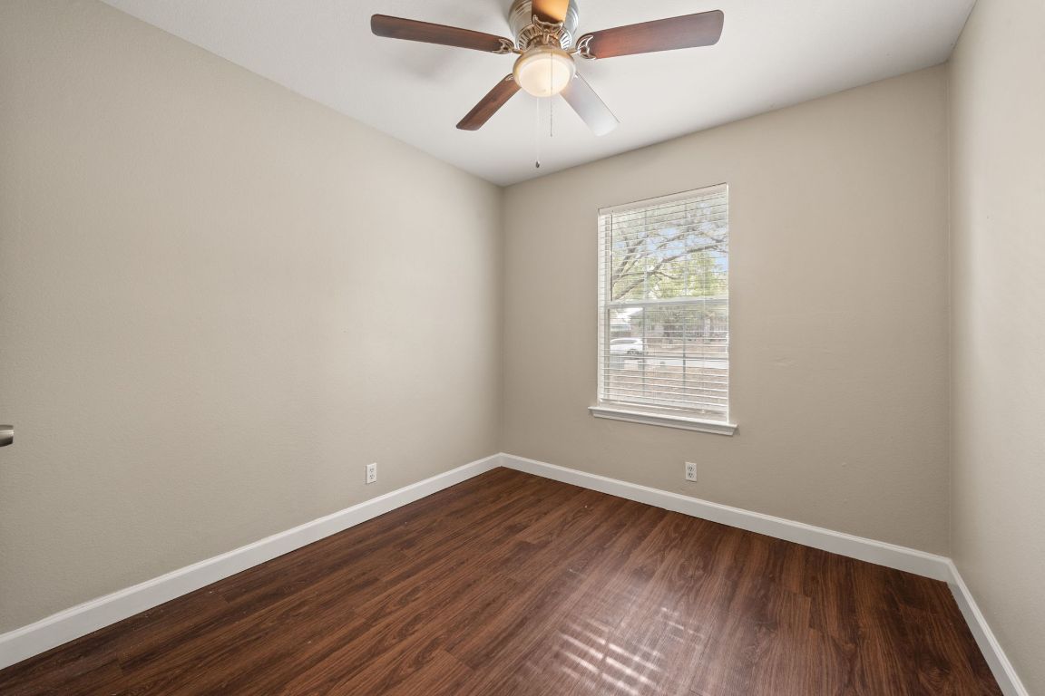 4904 Gnarled Oak Cove Austin, TX 78744 - Photo 4 of 38 a view of an empty room with wooden floor and a window