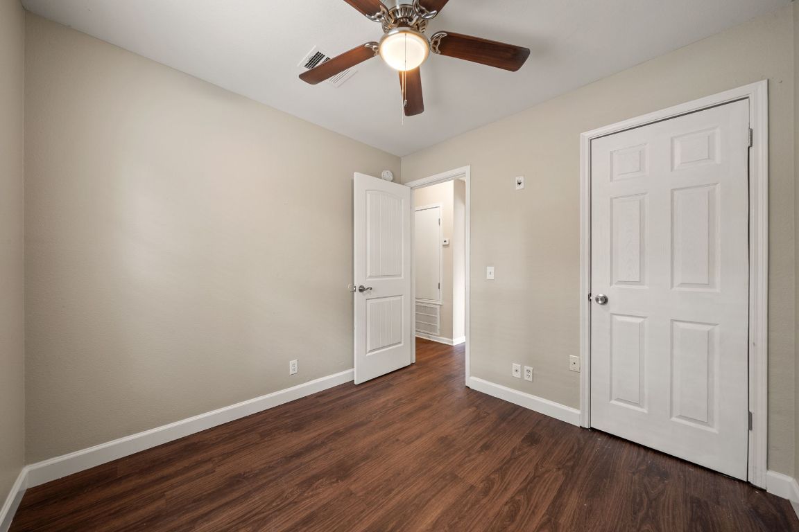 4904 Gnarled Oak Cove Austin, TX 78744 - Photo 6 of 38 an empty room with wooden floor a ceiling fan and closet