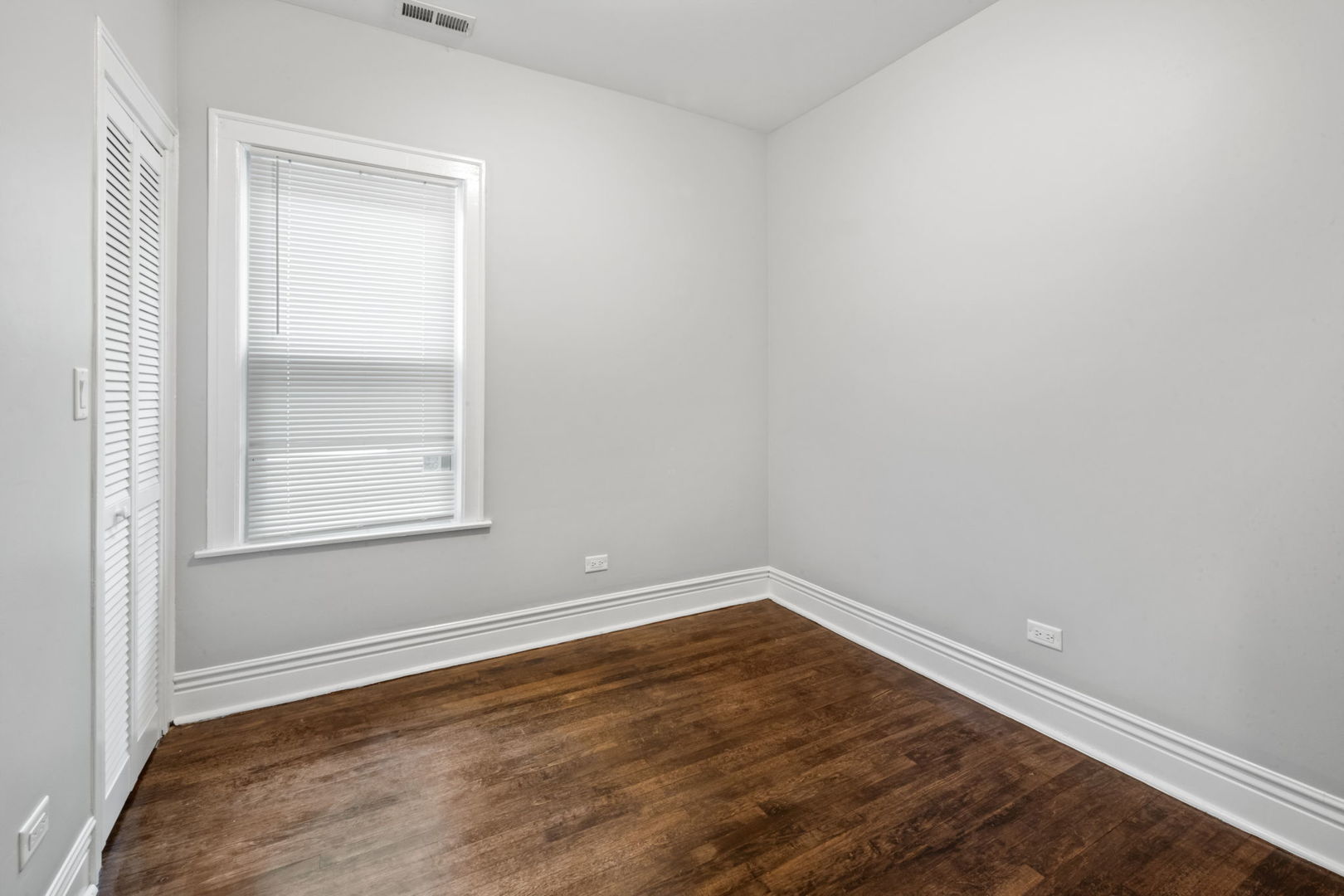 8548 South Exchange Avenue Chicago, IL 60617 - Photo 11 of 32 a view of an empty room with wooden floor and a window