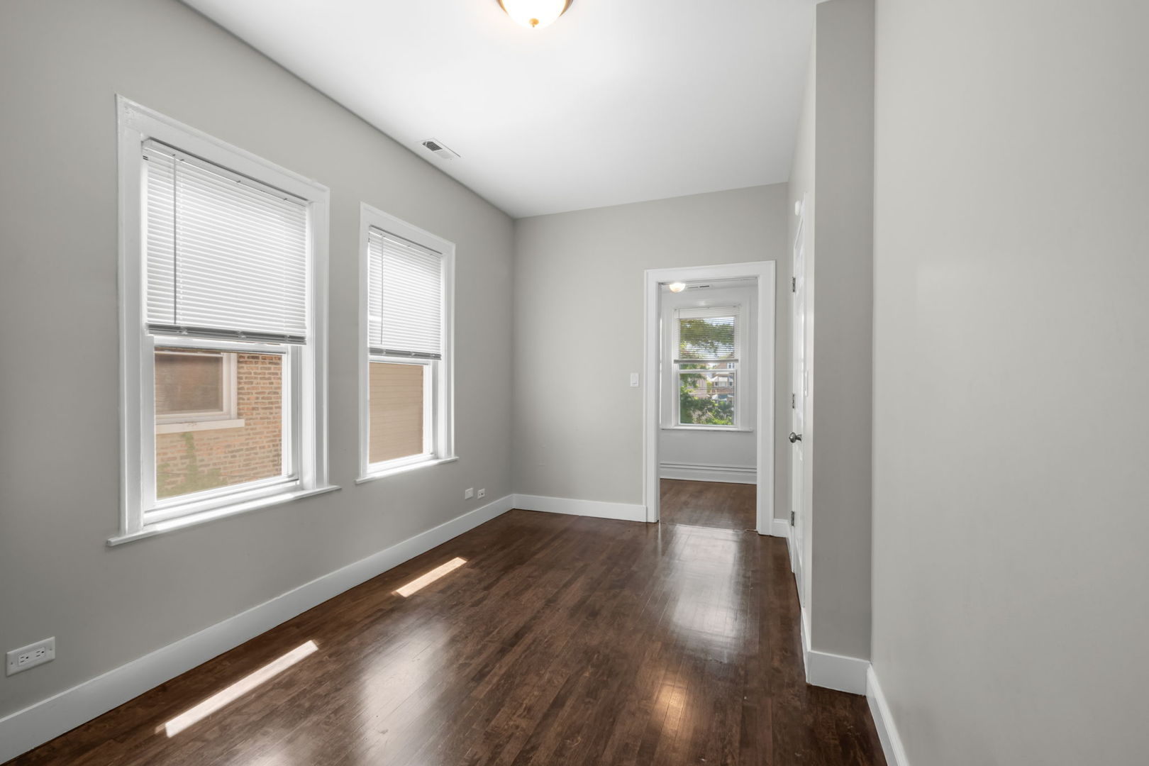 8548 South Exchange Avenue Chicago, IL 60617 - Photo 17 of 32 a view of an empty room with wooden floor and a window