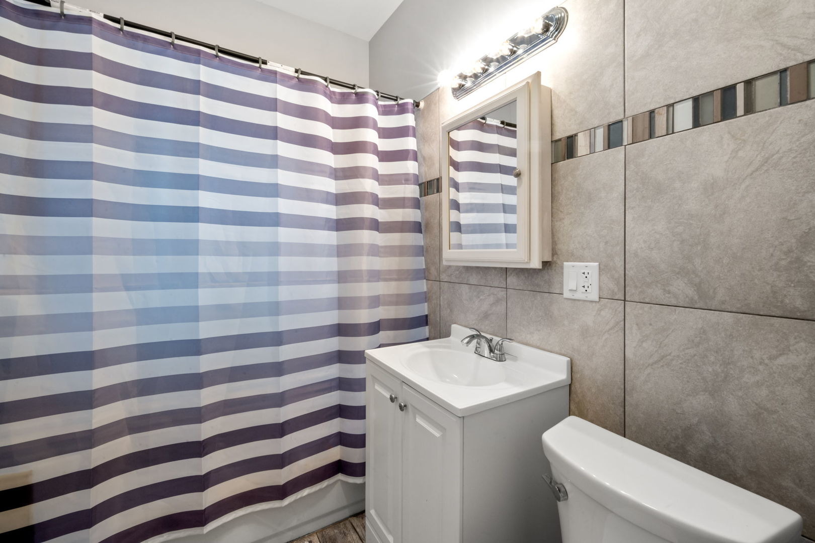 8548 South Exchange Avenue Chicago, IL 60617 - Photo 20 of 32 a bathroom with a sink a toilet and shower curtain