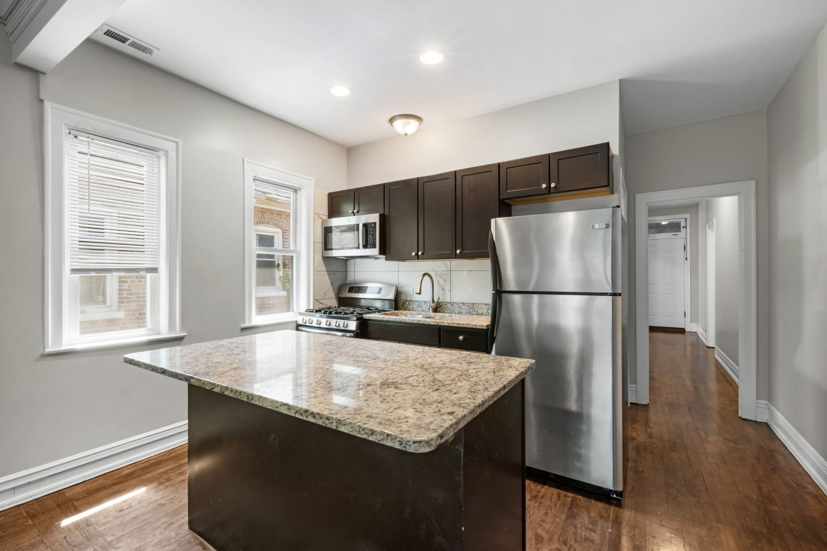 8548 South Exchange Avenue Chicago, IL 60617 - Photo 8 of 32 a kitchen with kitchen island a counter top space cabinets a refrigerator and a sink
