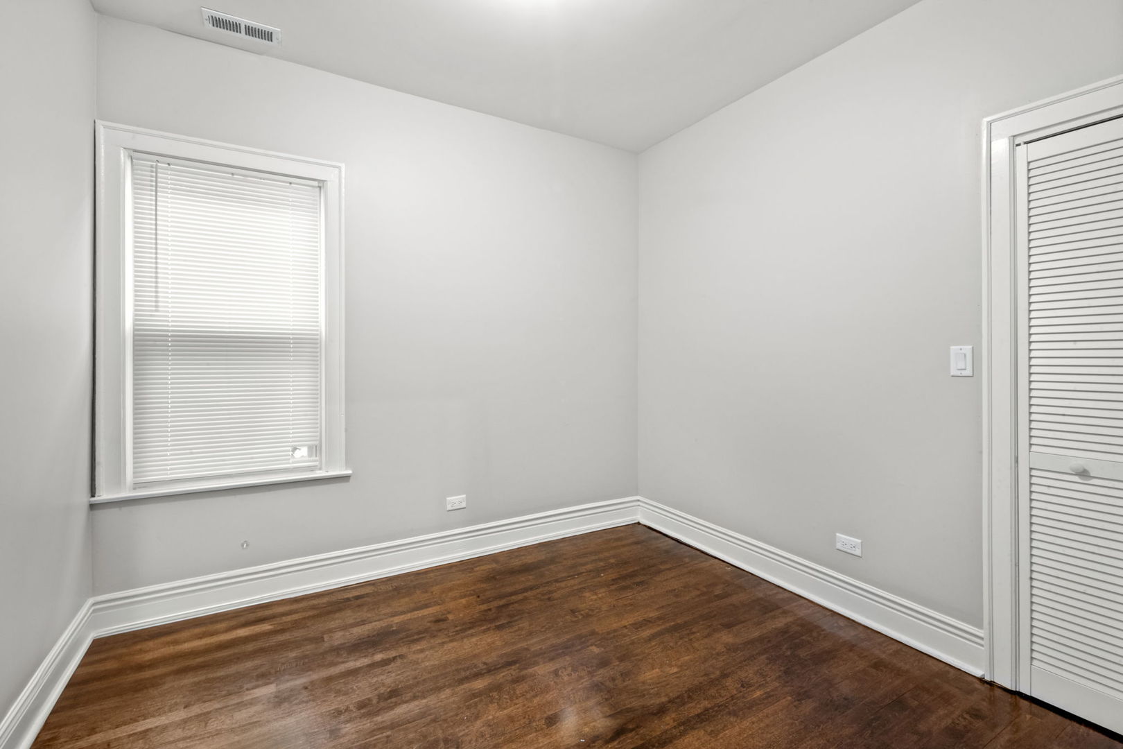 8548 South Exchange Avenue Chicago, IL 60617 - Photo 10 of 32 an empty room with wooden floor and windows