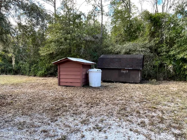 a backyard of a house with wooden fence and trees