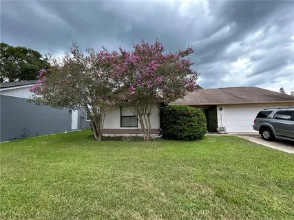 a view of a house with a yard and a car parked in it