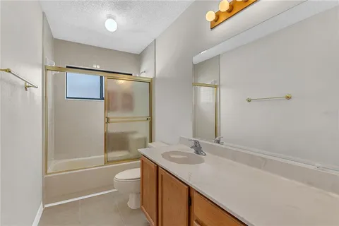 a white house that has a toilet and a wooden fence