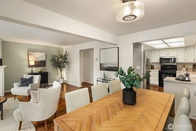 a dining room with furniture a potted plant and a large mirror