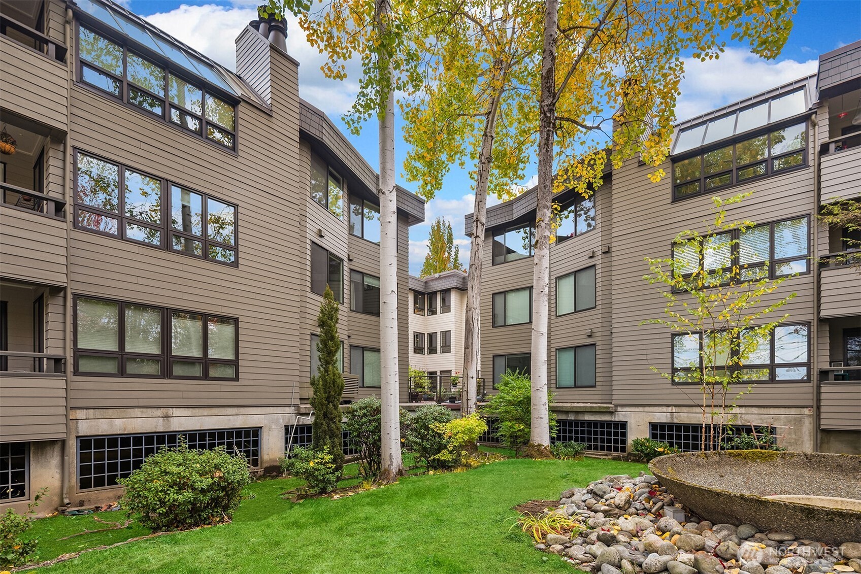 6300 Sand Point Way Northeast, Unit 212 Seattle, WA 98115 - Photo 21 of 21 a view of a brick building next to a yard