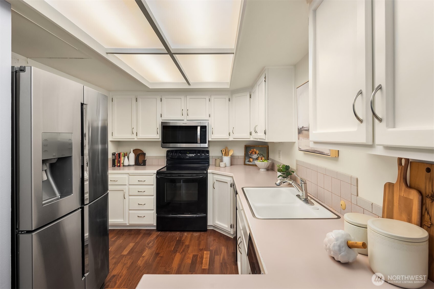 6300 Sand Point Way Northeast, Unit 212 Seattle, WA 98115 - Photo 6 of 21 a kitchen with stainless steel appliances a refrigerator sink and white cabinets