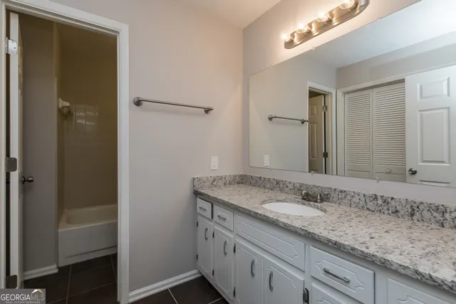 a bathroom with a granite countertop sink and a mirror