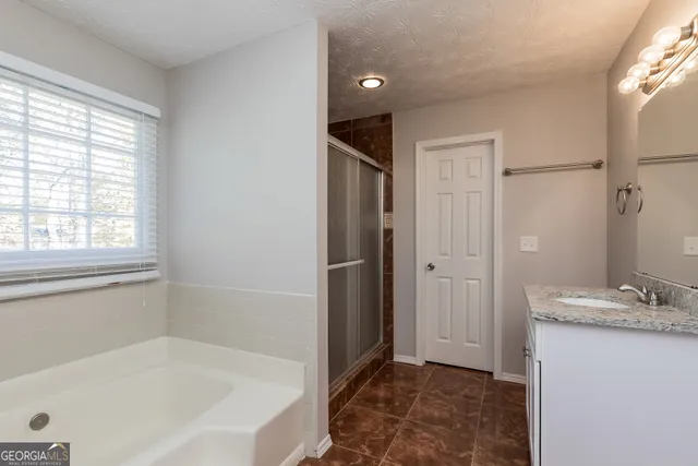 a bathroom with a tub shower and a sink