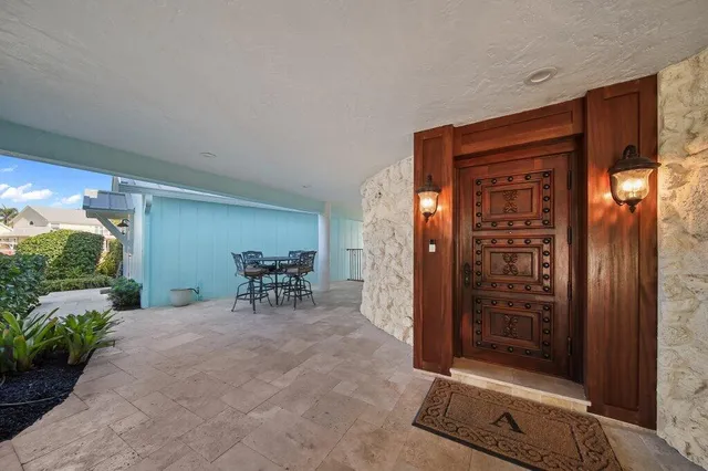 a view of a chair and an empty room with wooden floor