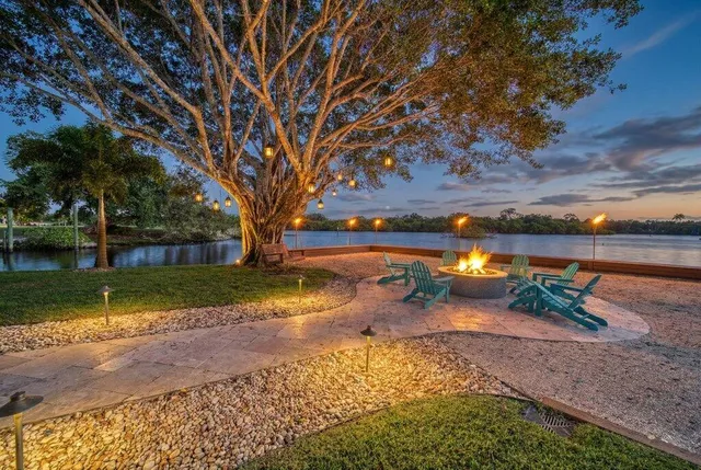a front view of a house with a garden and palm trees