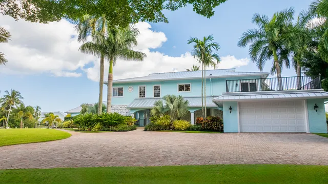 a kitchen with stainless steel appliances kitchen island a table and chairs in it