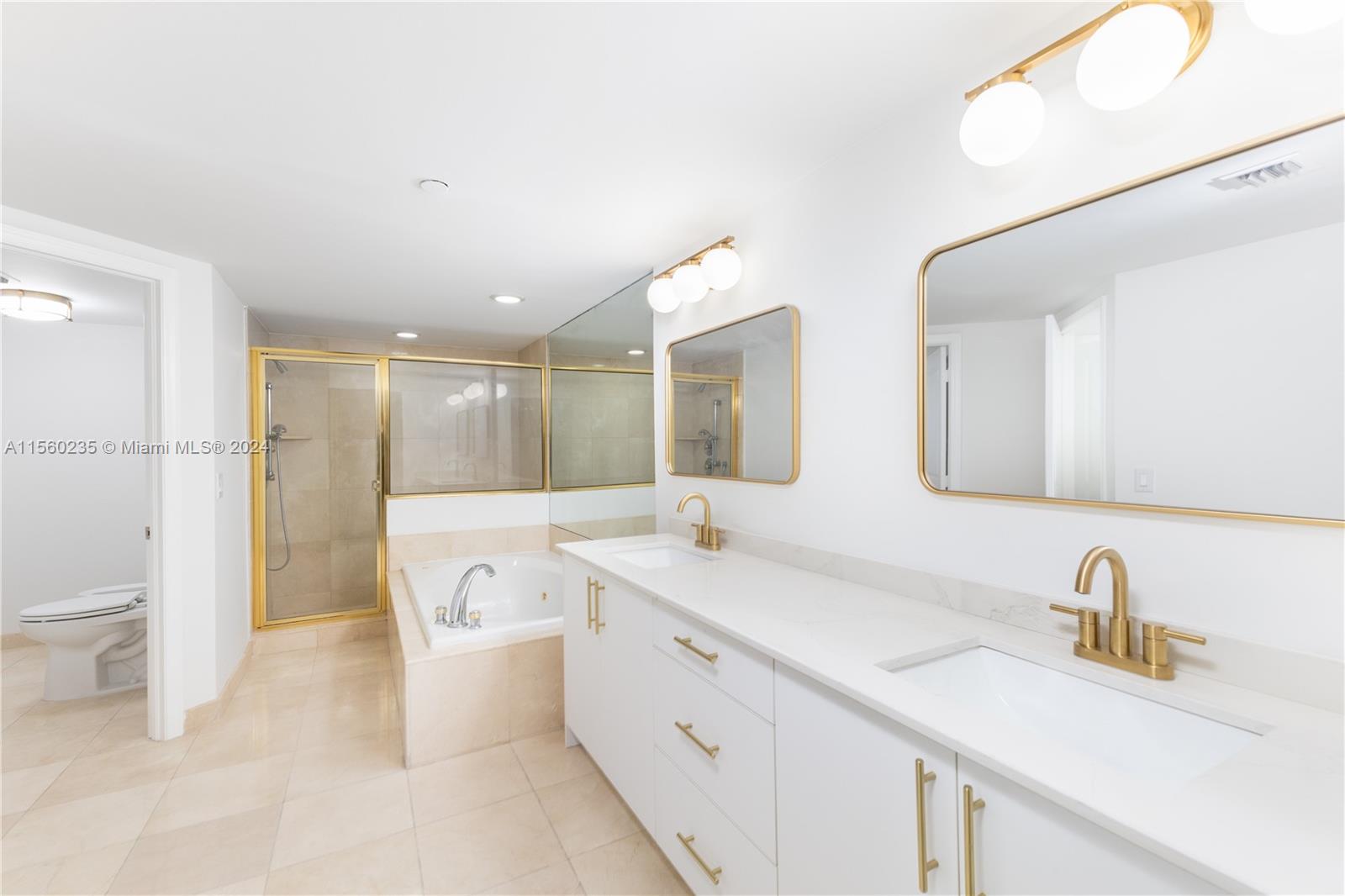 8925 Collins Avenue, Unit 2J Surfside, FL 33154 - Photo 48 of 62 a spacious bathroom with a double vanity sink mirror and toilet