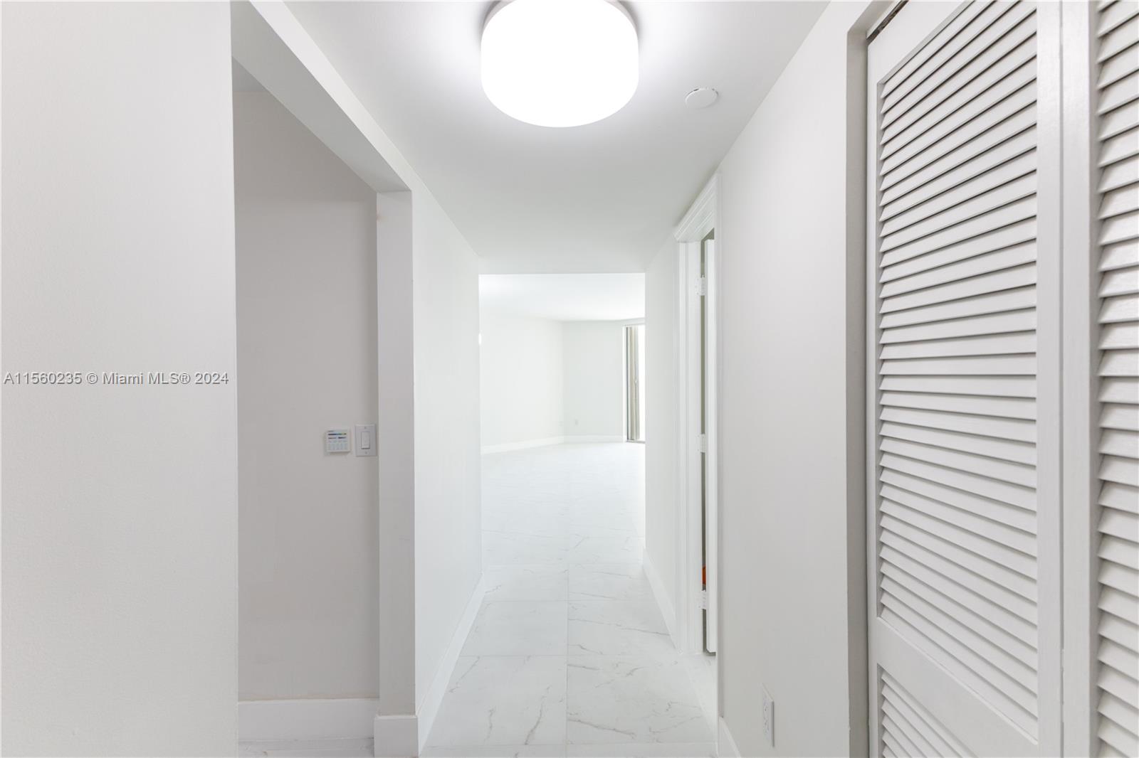 8925 Collins Avenue, Unit 2J Surfside, FL 33154 - Photo 59 of 62 a view of a hallway with wooden floor
