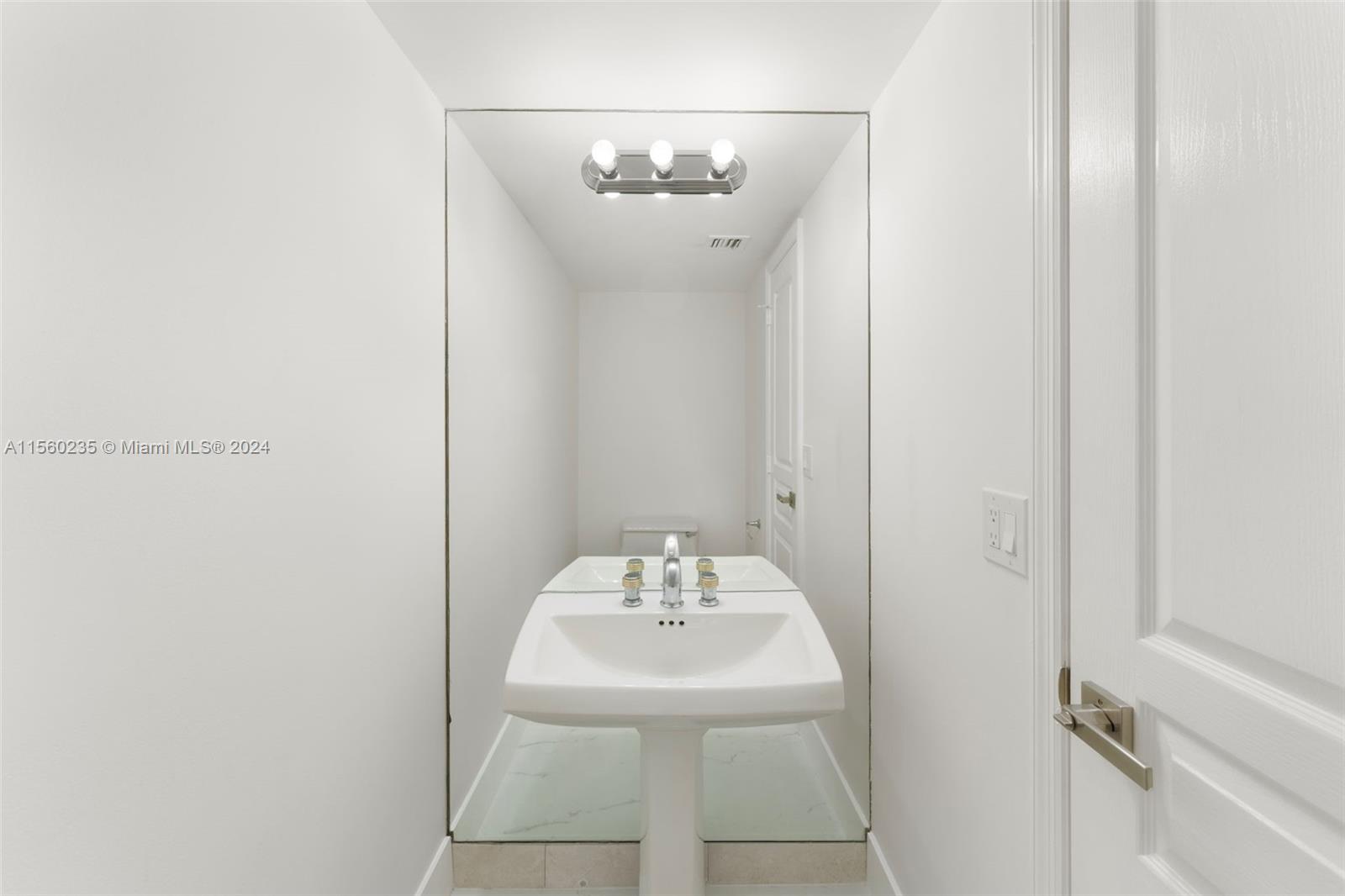 8925 Collins Avenue, Unit 2J Surfside, FL 33154 - Photo 8 of 62 a bathroom with a sink and a mirror
