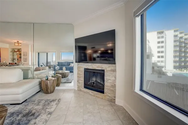 a living room with furniture a large window and a fireplace