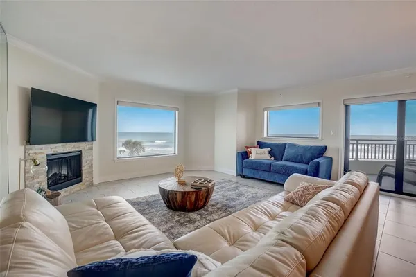 a living room with furniture a fireplace and a flat screen tv