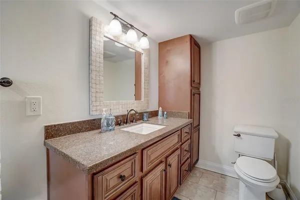 a bathroom with a granite countertop sink a toilet and shower
