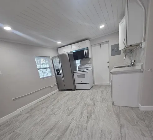 a view of a kitchen with refrigerator and cabinet