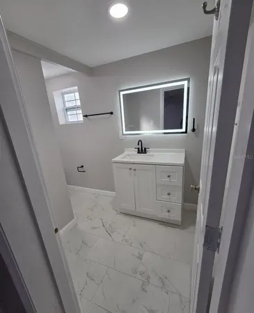 a bathroom with a granite countertop sink a mirror and a vanity