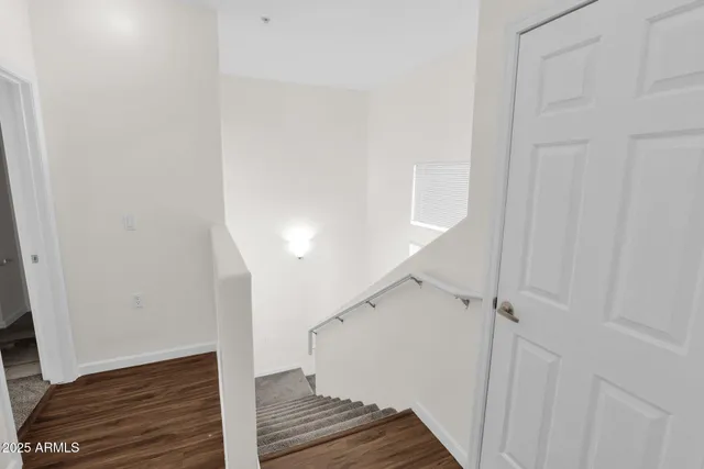 a view of a hallway with wooden floor and staircase